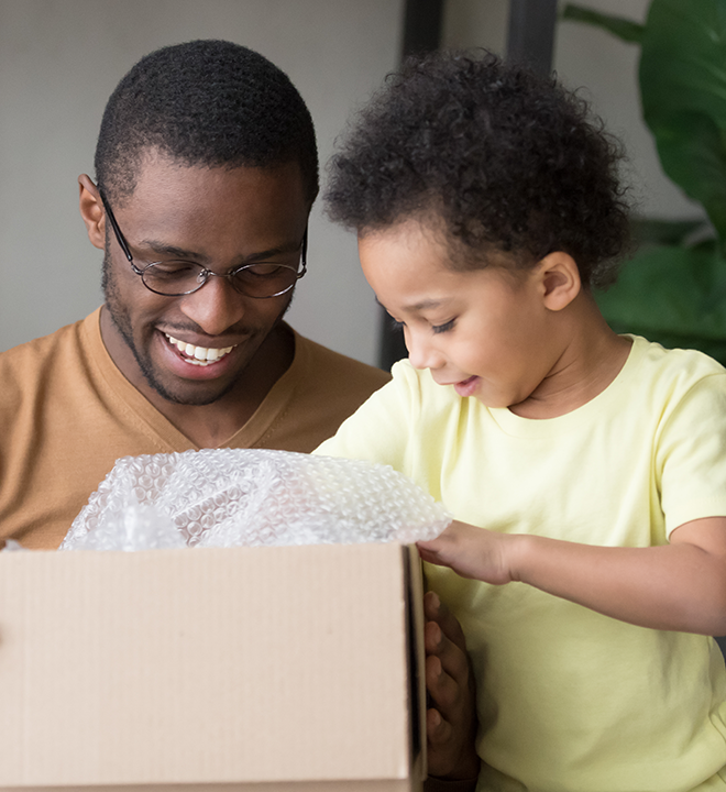 An adult and child opening a box while smiling