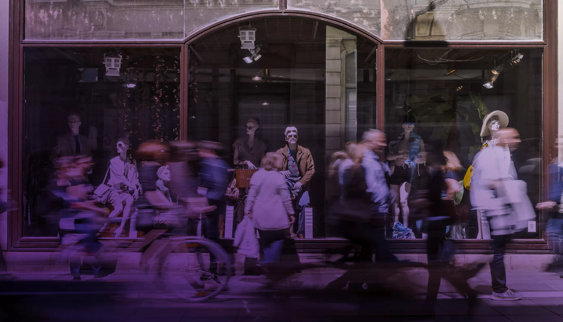 Blurred image of people walking by a storefront
